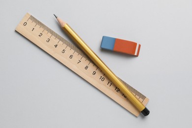 Photo of Eraser, pencil and ruler on light background, top view