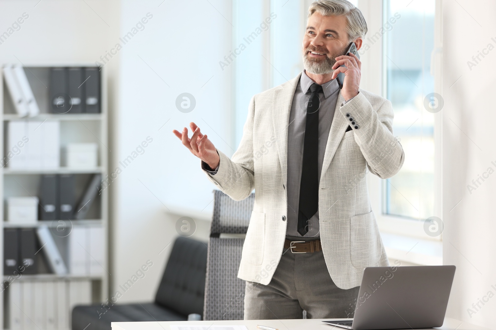 Photo of Banker talking on smartphone in office, space for text