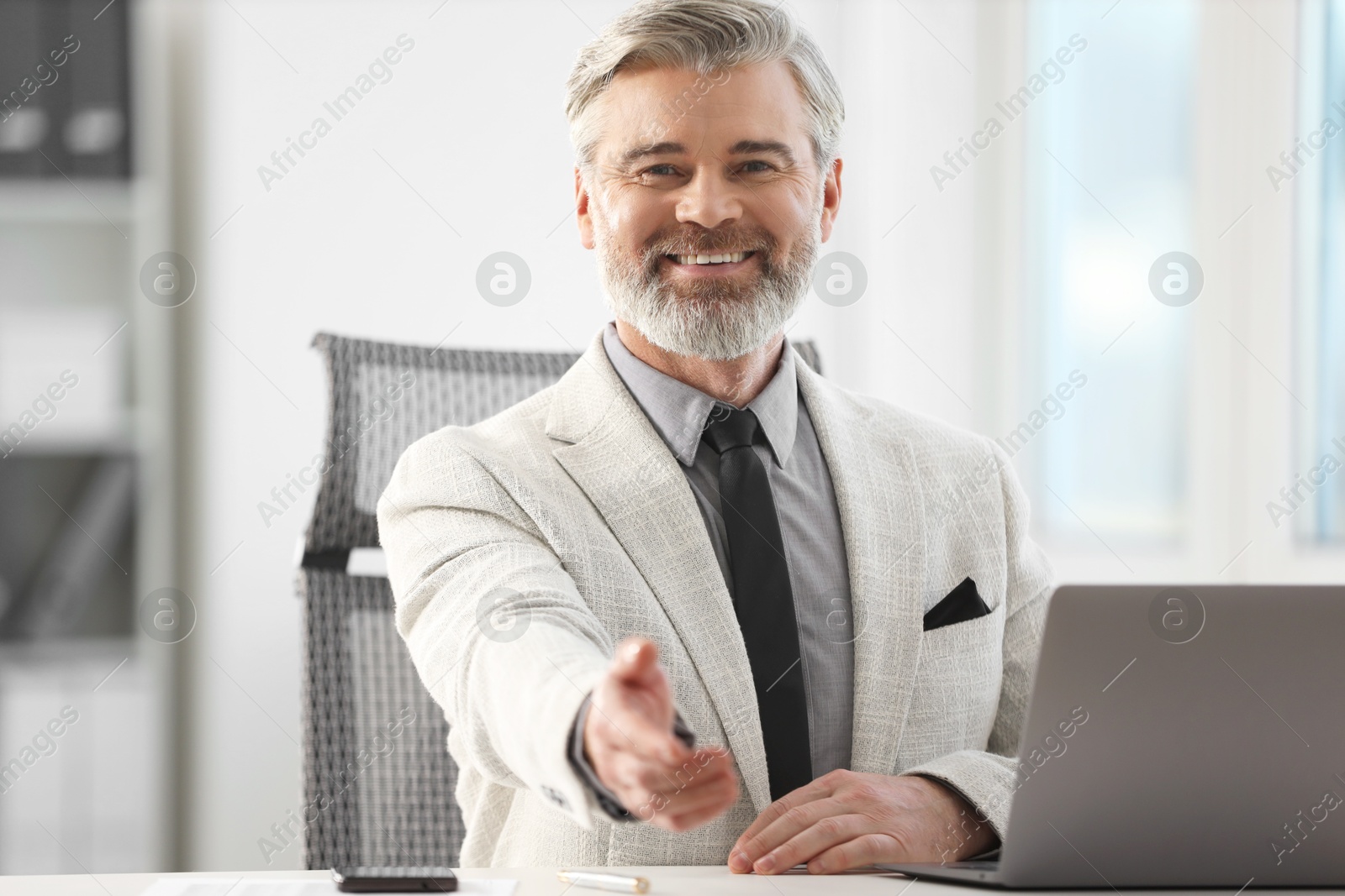 Photo of Portrait of happy banker at desk in office