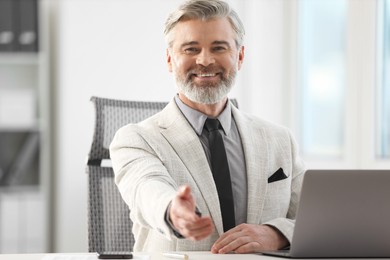 Photo of Portrait of happy banker at desk in office