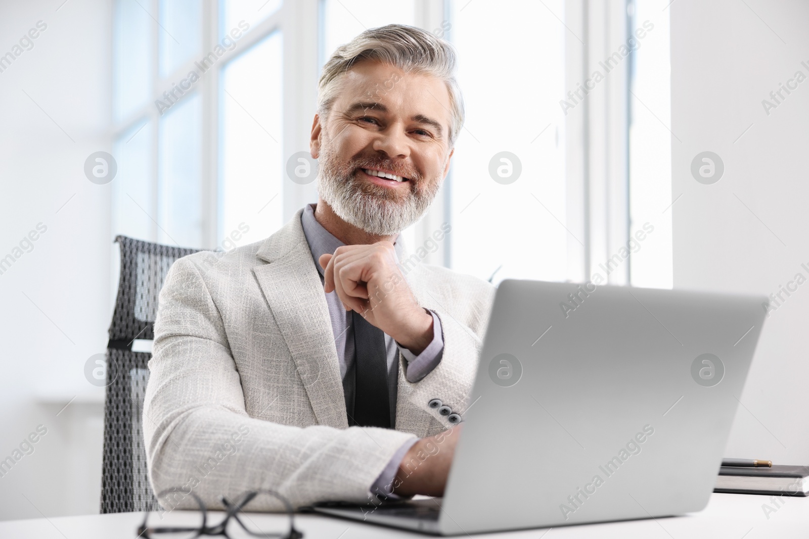 Photo of Banker working on laptop at desk in office