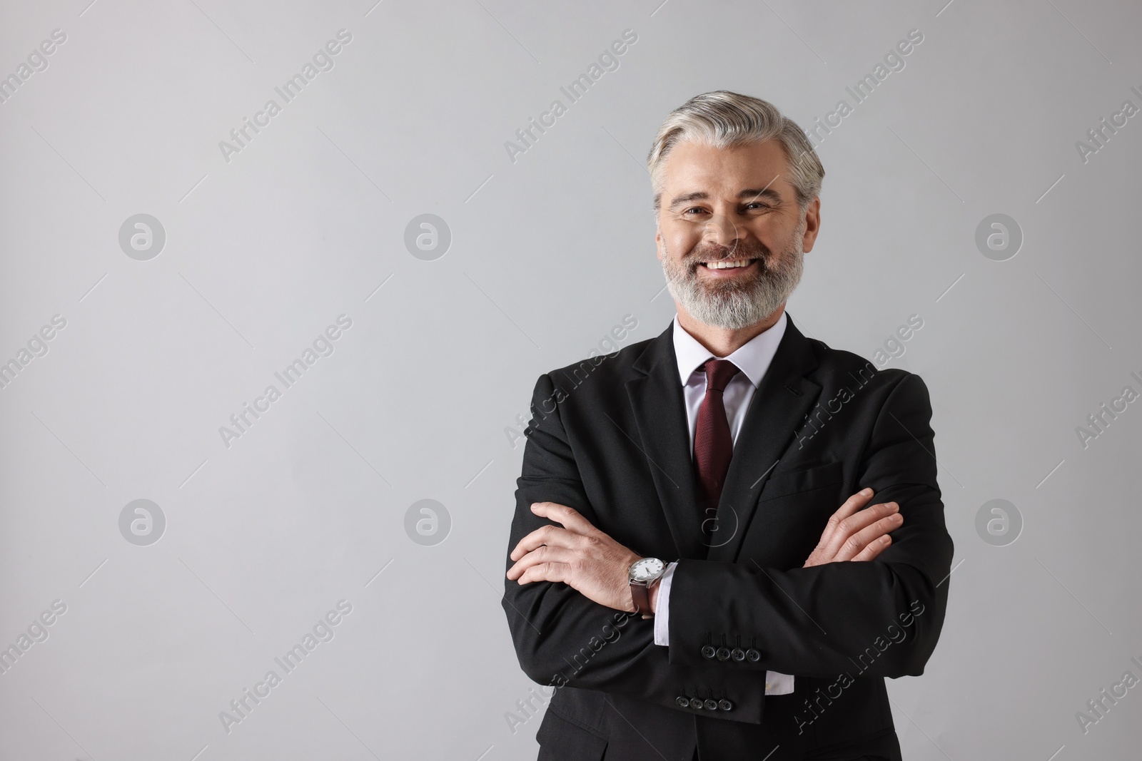 Photo of Portrait of banker with crossed arms on grey background, space for text