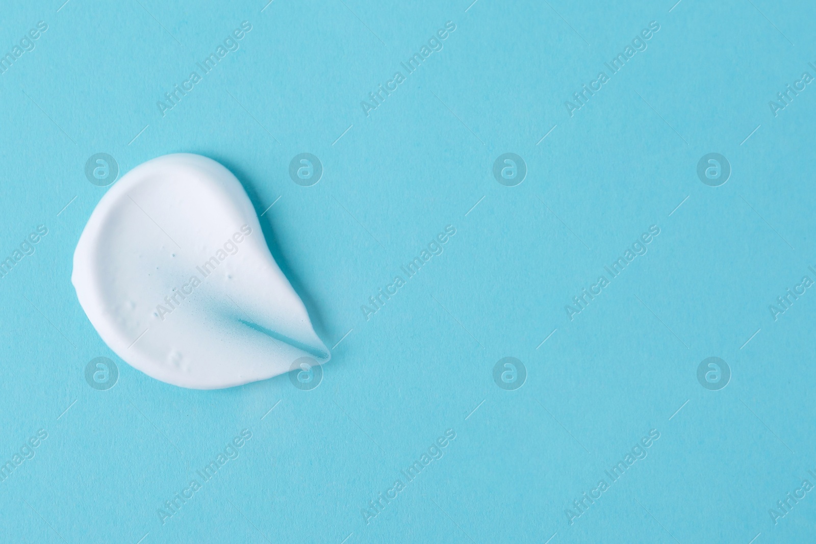 Photo of Sample of fluffy foam on light blue background, top view. Space for text