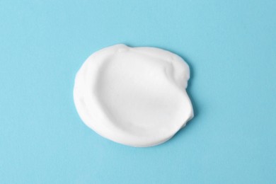 Photo of Sample of fluffy foam on light blue background, top view