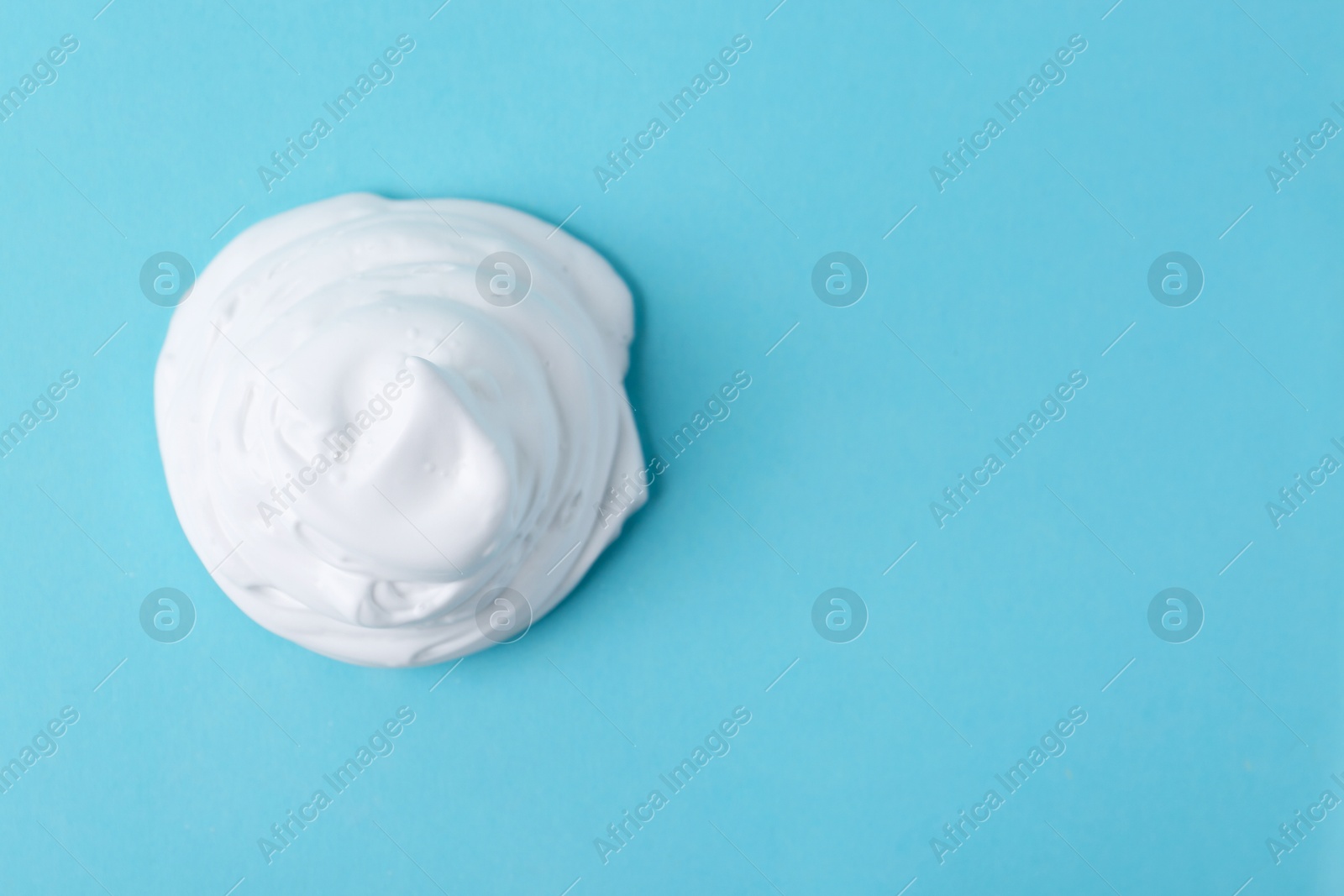 Photo of Sample of fluffy foam on light blue background, top view. Space for text