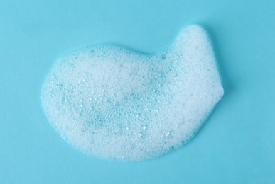 Photo of Sample of fluffy foam on light blue background, top view