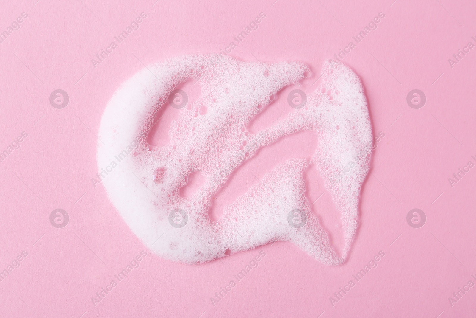 Photo of Sample of fluffy foam on pink background, top view