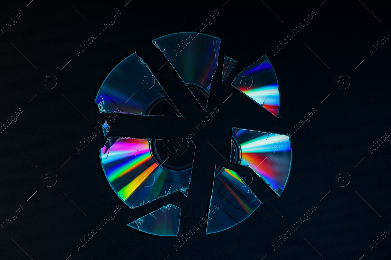 Photo of Broken compact disc on black background, top view