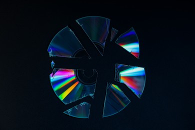 Photo of Broken compact disc on black background, top view