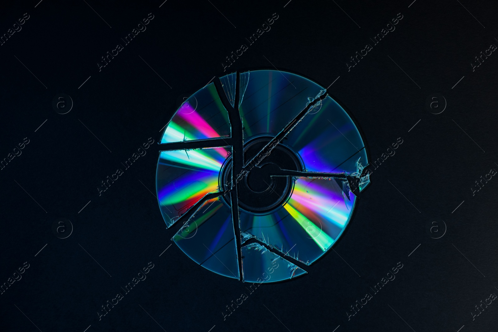 Photo of Broken compact disc on black background, top view