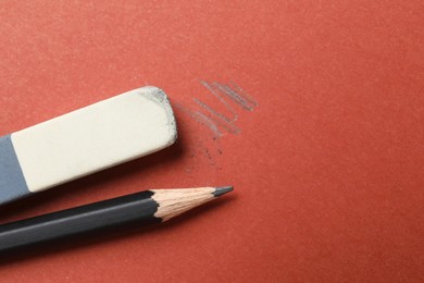 Photo of Eraser and pencil on brown background, flat lay. Space for text