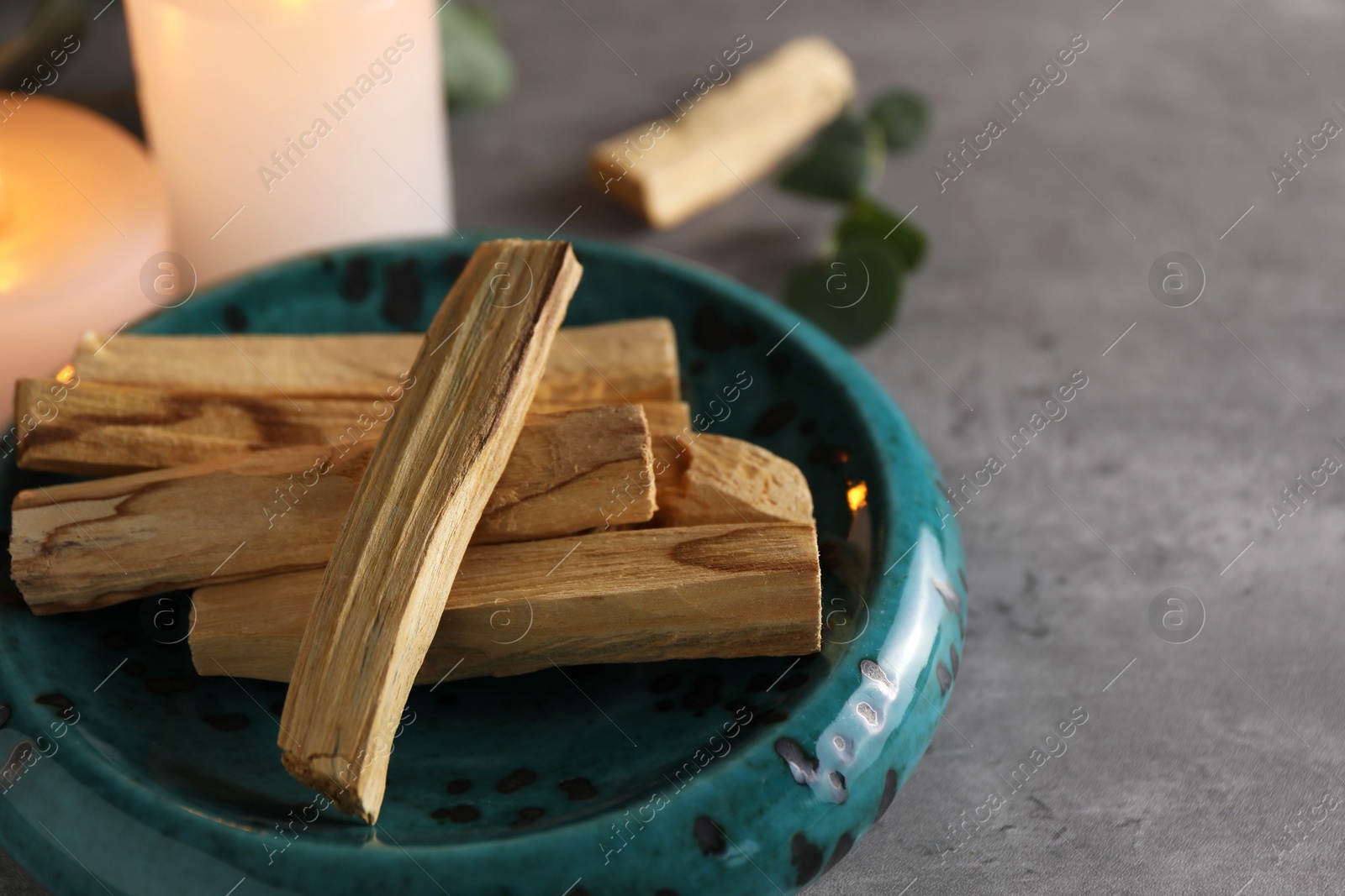 Photo of Palo santo sticks on grey table, closeup. Space for text