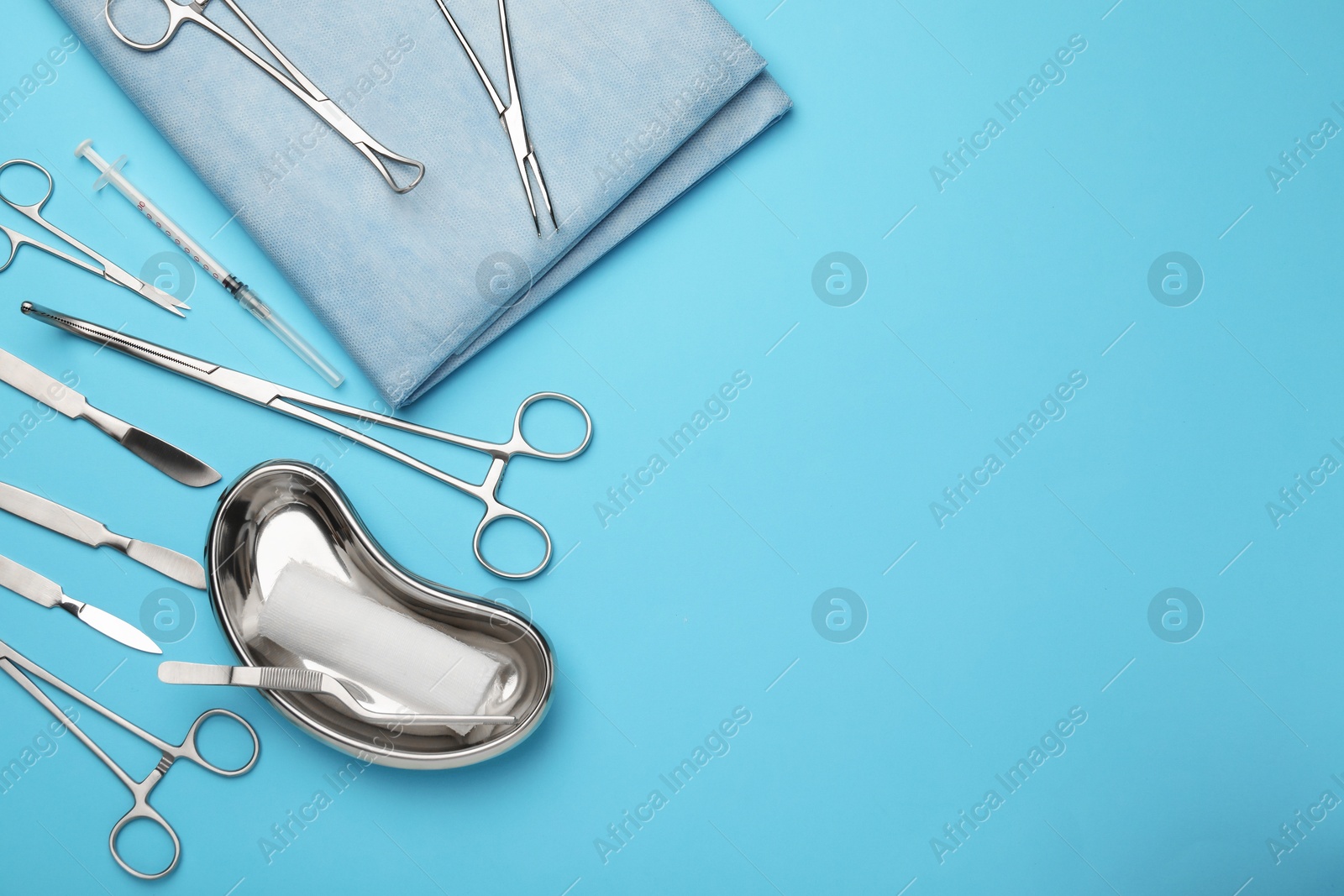 Photo of Different surgical tools on light blue background, flat lay. Space for text