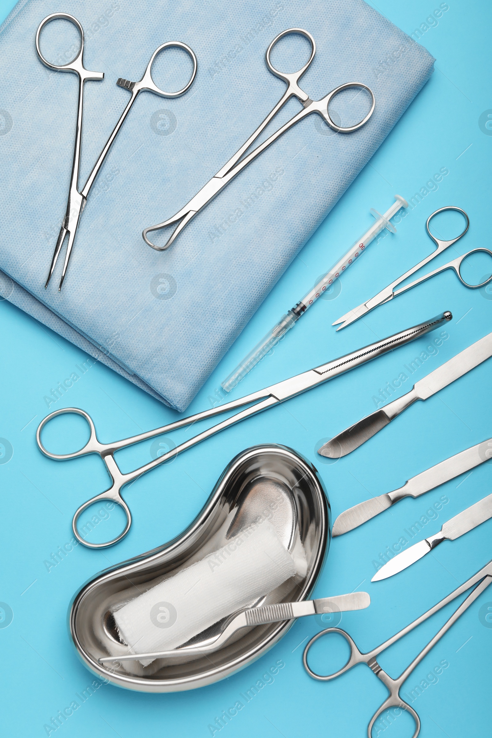 Photo of Different surgical tools on light blue background, flat lay