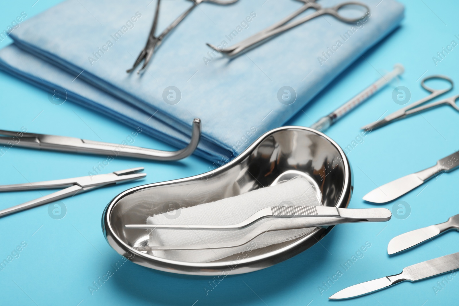 Photo of Different surgical tools on light blue background, closeup