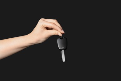 Photo of Woman with car key on black background, closeup. Space for text