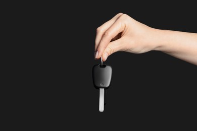 Photo of Woman with car key on black background, closeup. Space for text