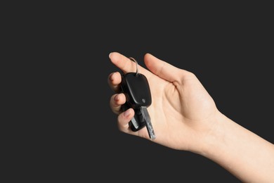 Photo of Woman with car keys on black background, closeup. Space for text