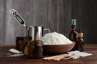 Photo of Soy wax and other supplies for making candles on wooden table