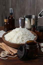 Photo of Soy wax and other supplies for making candles on wooden table, closeup