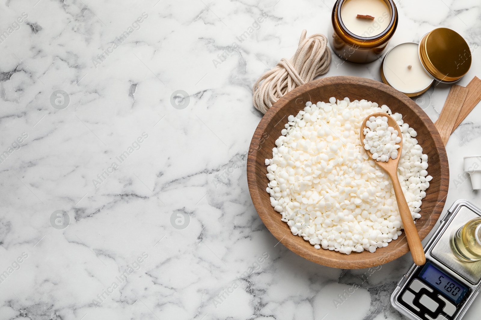 Photo of Soy wax and other supplies for making candles on white marble table, flat lay. Space for text