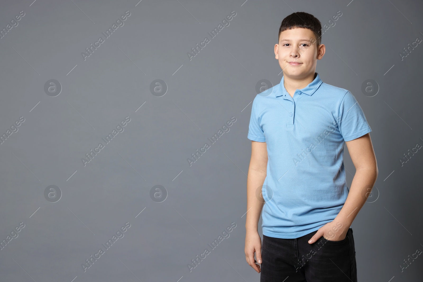 Photo of Portrait of teenage boy on grey background, space for text