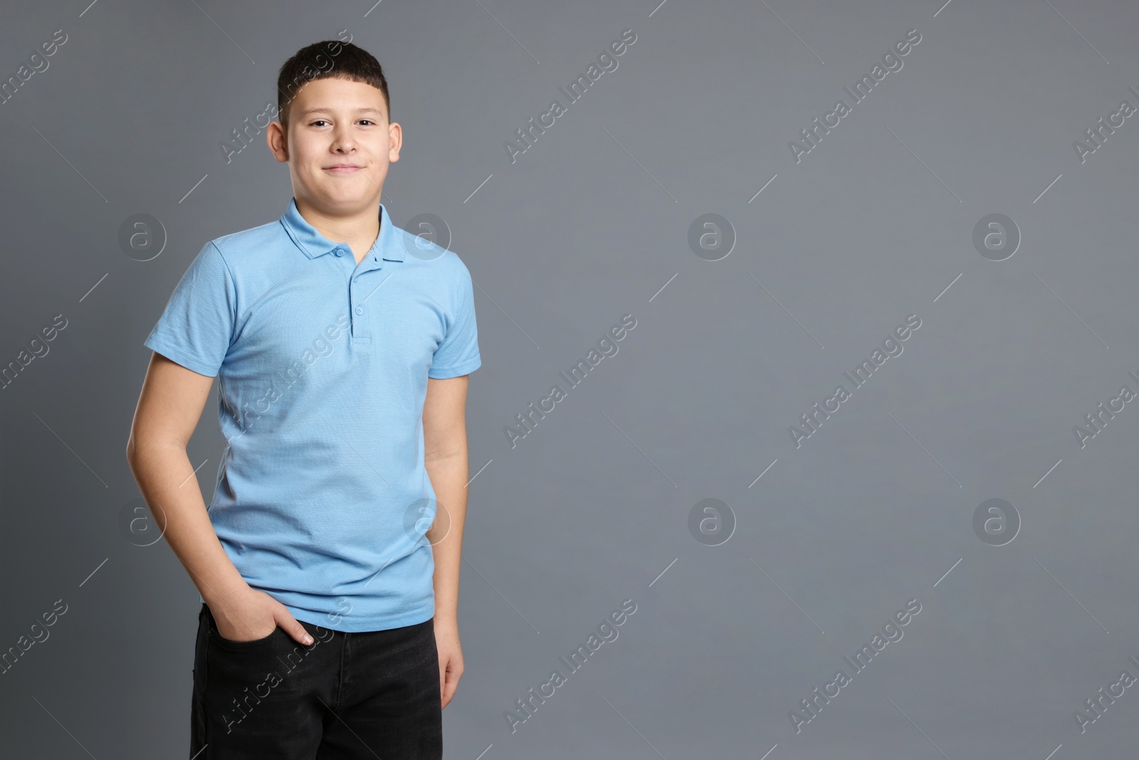 Photo of Portrait of teenage boy on grey background, space for text