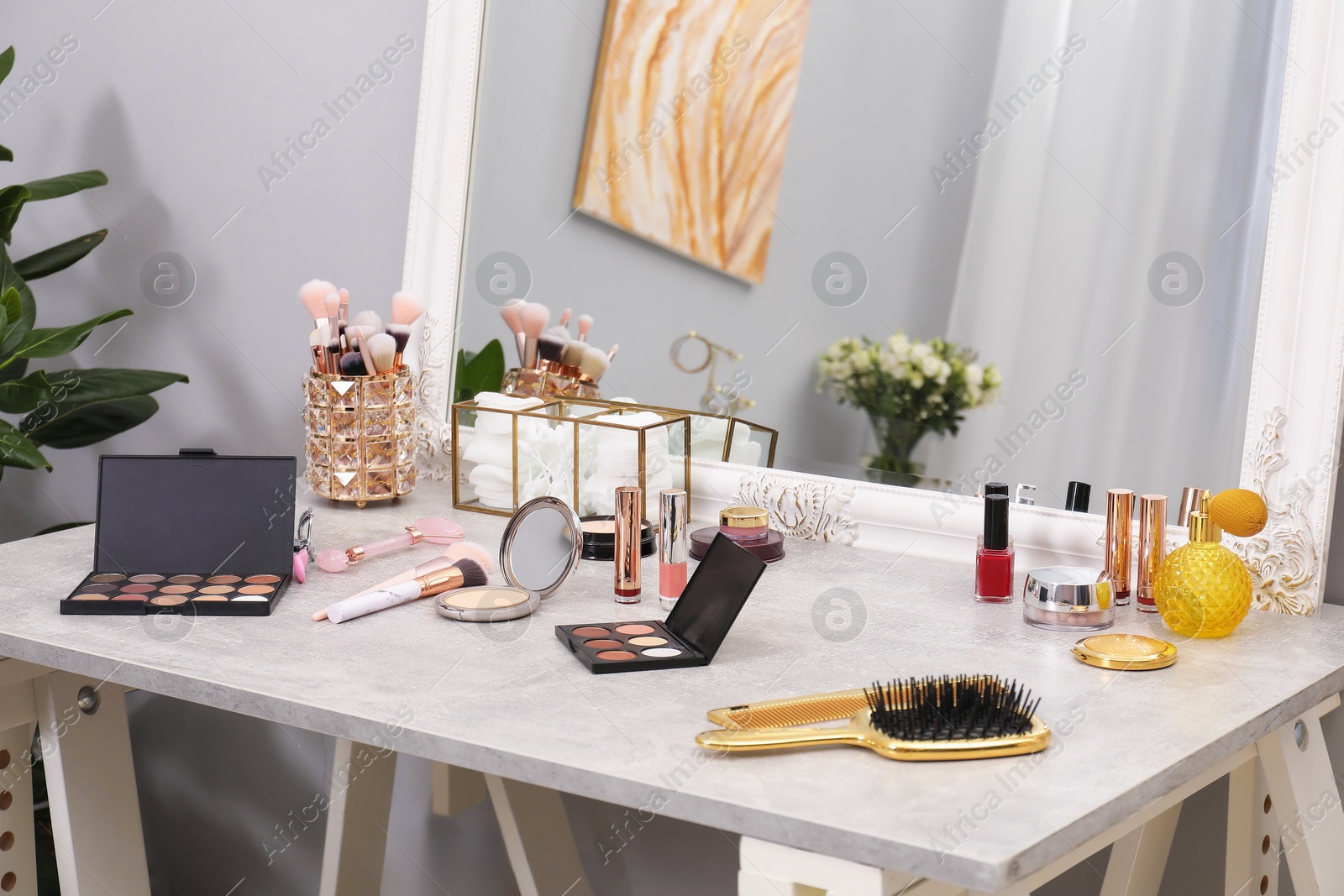 Photo of Makeup room. Different beauty products on dressing table and mirror indoors