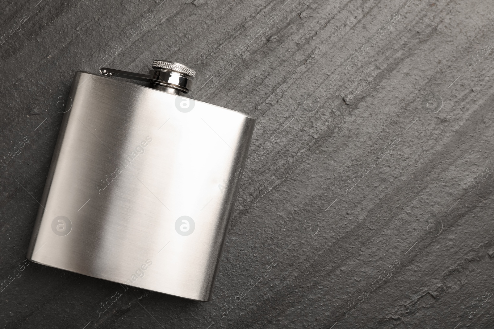 Photo of One hip flask on black table, top view. Space for text