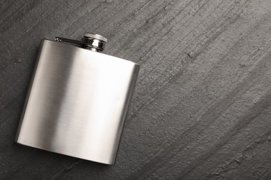 Photo of One hip flask on black table, top view. Space for text