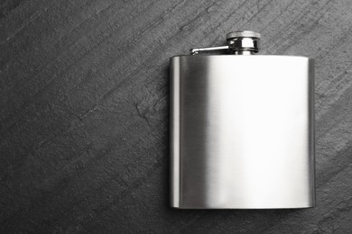 Photo of One hip flask on black table, top view. Space for text