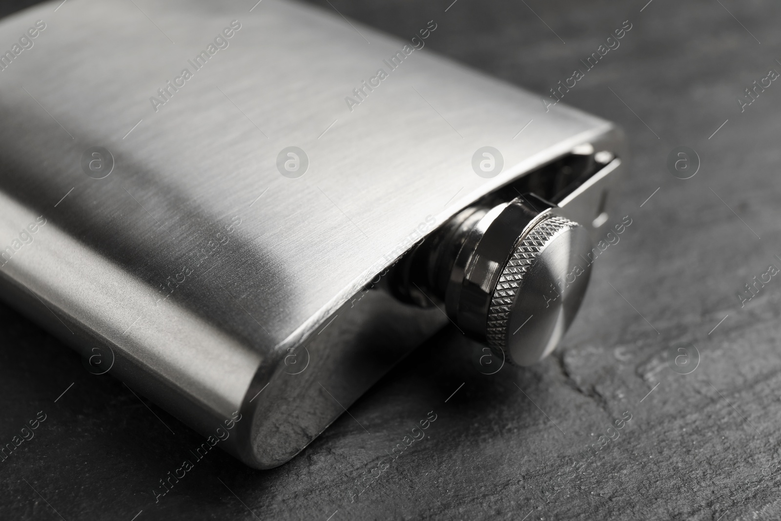 Photo of One hip flask on black table, closeup