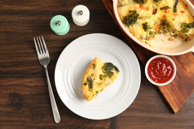 Photo of Tasty vegetable casserole served with sauce and spices on wooden table, flat lay