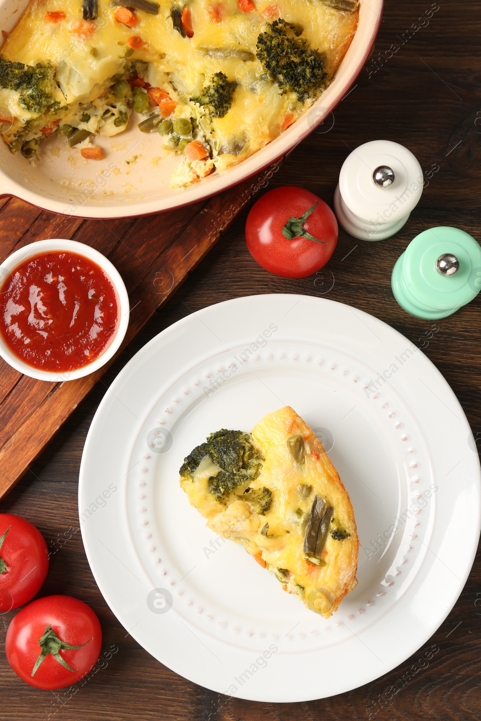 Photo of Tasty vegetable casserole, sauce and spices on wooden table, flat lay