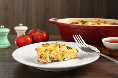 Photo of Piece of tasty vegetable casserole on wooden table, closeup