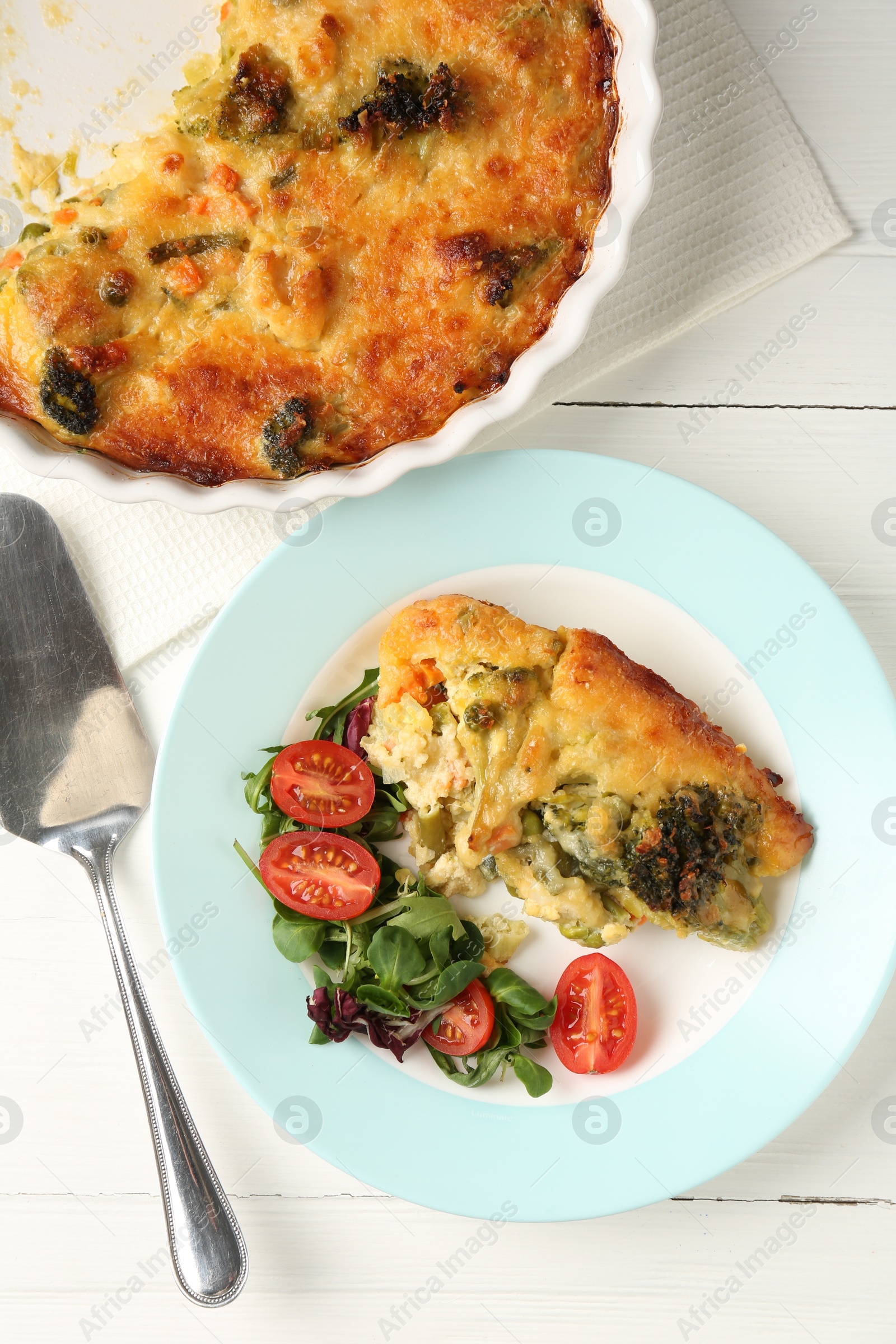 Photo of Tasty vegetable casserole and salad on white wooden table, flat lay