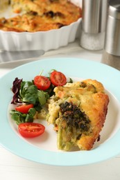 Photo of Tasty vegetable casserole and salad on white wooden table, closeup