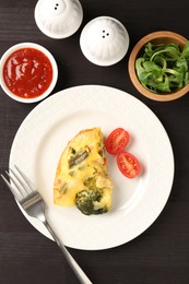 Photo of Tasty vegetable casserole served on black wooden table, flat lay