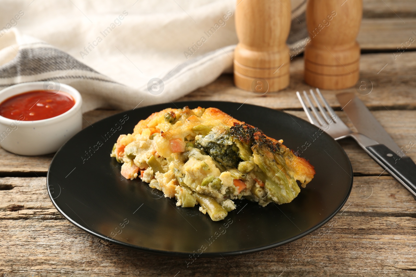 Photo of Tasty vegetable casserole on wooden table, closeup