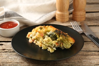 Photo of Tasty vegetable casserole on wooden table, closeup