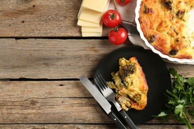 Photo of Tasty vegetable casserole, products and cutlery on wooden table, flat lay. Space for text