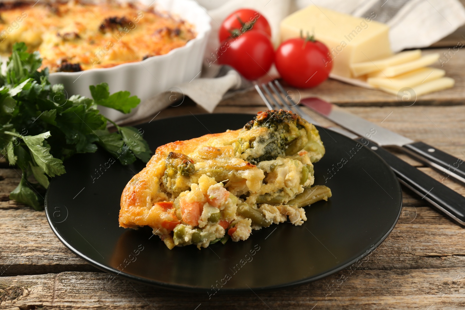 Photo of Tasty vegetable casserole on wooden table, closeup