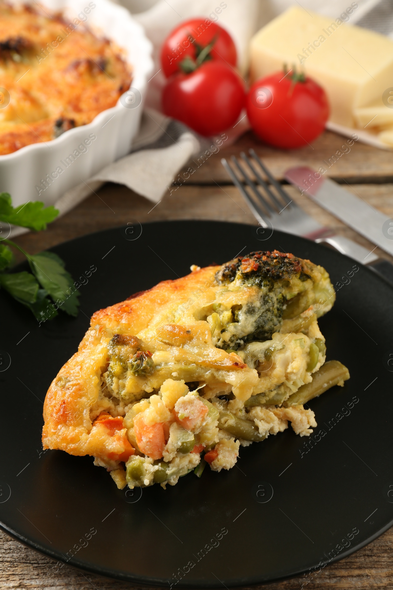 Photo of Tasty vegetable casserole on wooden table, closeup