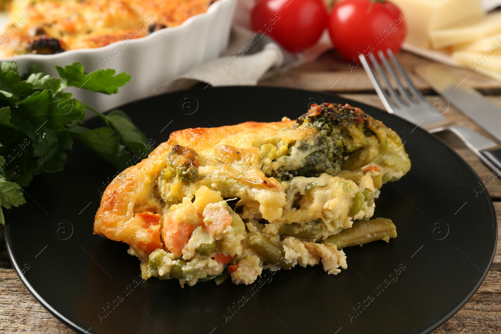 Photo of Tasty vegetable casserole on wooden table, closeup