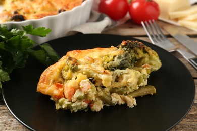 Photo of Tasty vegetable casserole on wooden table, closeup