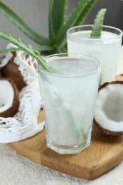 Photo of Refreshing drink with coconut and aloe on white textured table, closeup