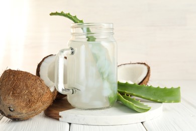 Photo of Refreshing drink with coconut and aloe on white wooden table