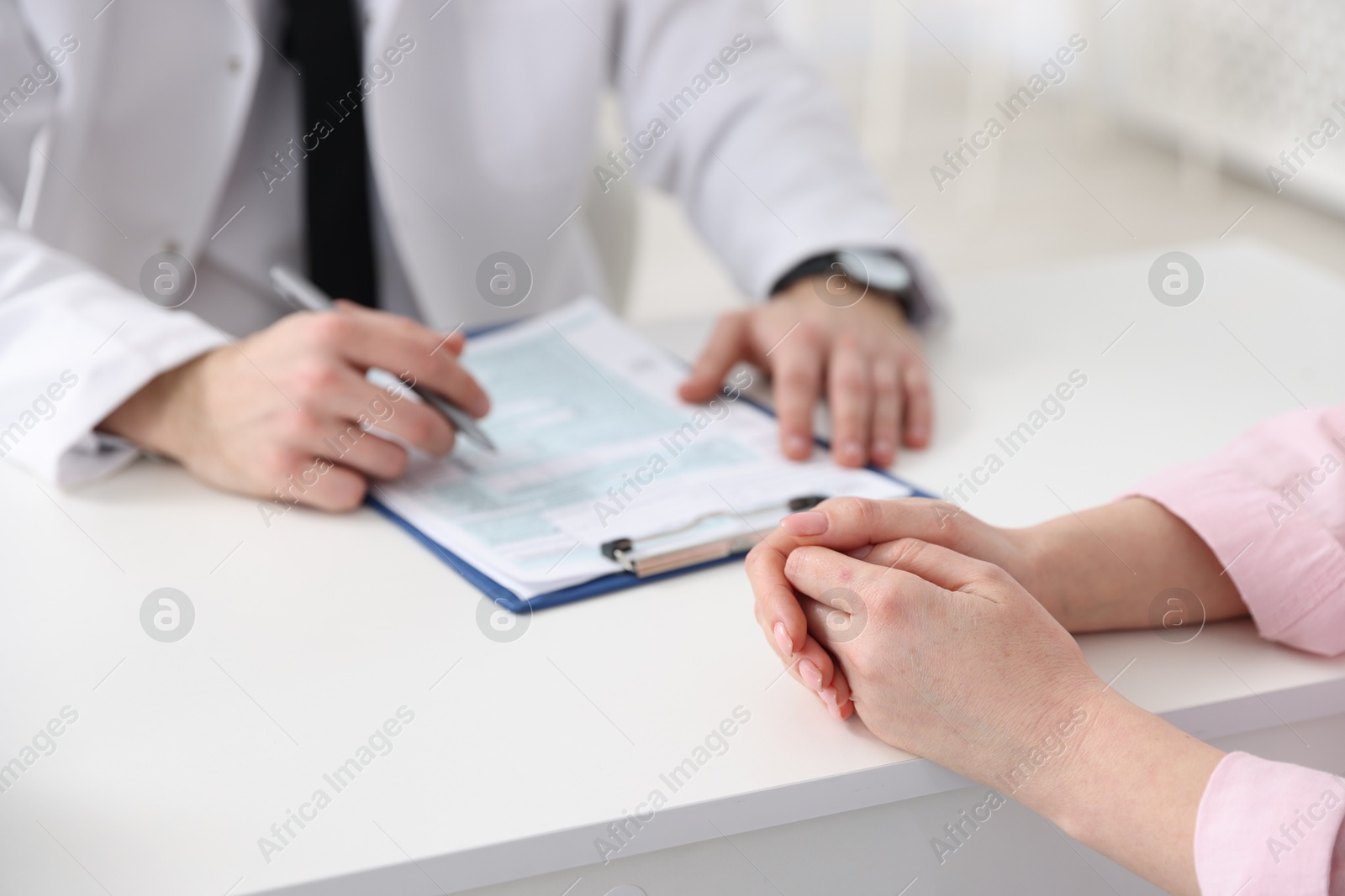 Photo of Woman having appointment with doctor in hospital, closeup