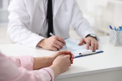 Photo of Woman having appointment with doctor in hospital, closeup