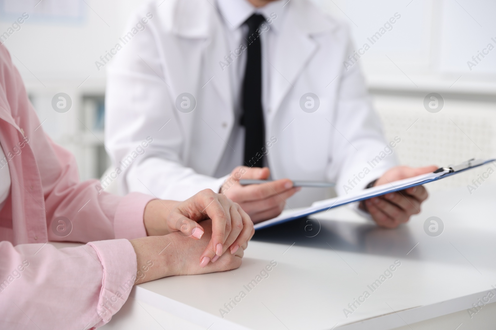 Photo of Woman having appointment with doctor in hospital, closeup